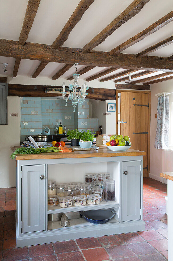 Kücheninsel in einer mit Terrakotta gefliesten Küche in einem unter Denkmalschutz stehenden Cottage (Grade II) in Hampshire, England UK