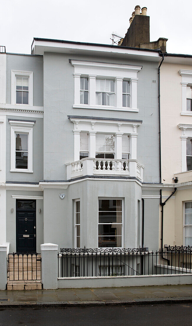 Light grey paintwork on facade of three-storey Victorian terraced house London England UK