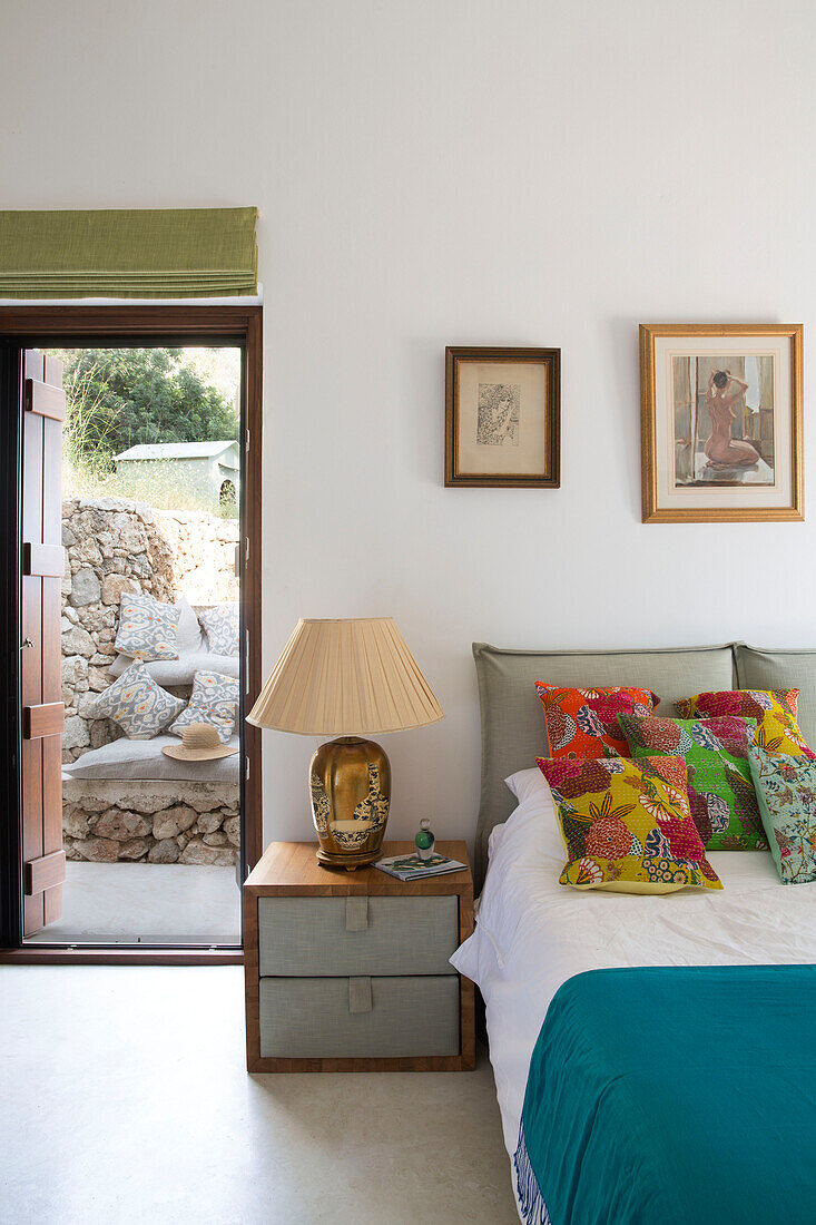 Nachttischlampe mit bunten Kissen und offener Tür im Schlafzimmer einer Villa in Ithaka Griechenland