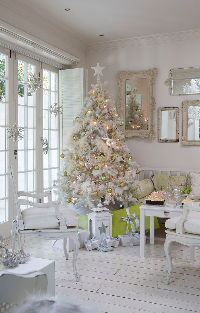 Weißer, mit lindgrünen Kugeln geschmückter Weihnachtsbaum im Haus einer Familie in Südlondon, England UK