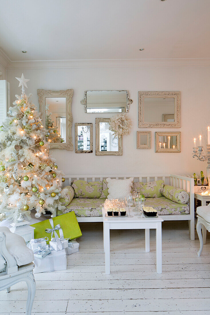 Künstlicher Weihnachtsbaum mit Spiegelsammlung in weißem Wohnzimmer im Süden Londons, England UK