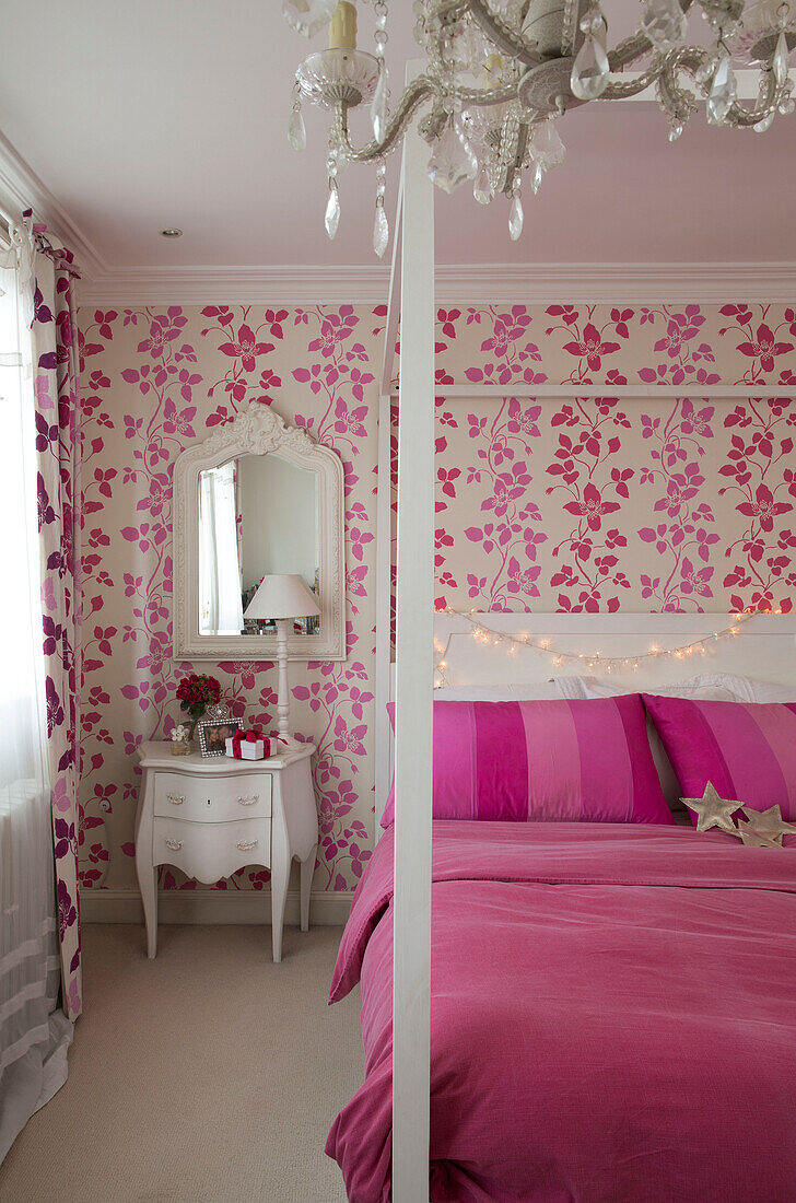 Hellrosa Decke auf Himmelbett mit Blumenpapier in einem Haus in South London, England UK