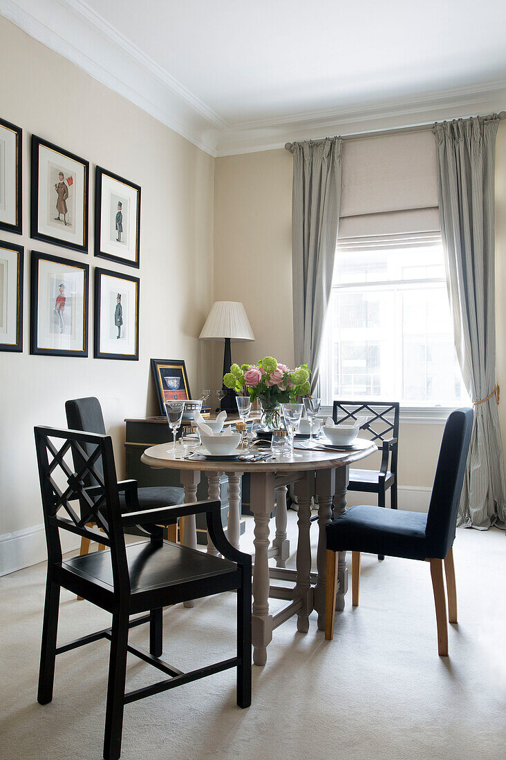 Dining table and framed prints in London townhouse apartment UK