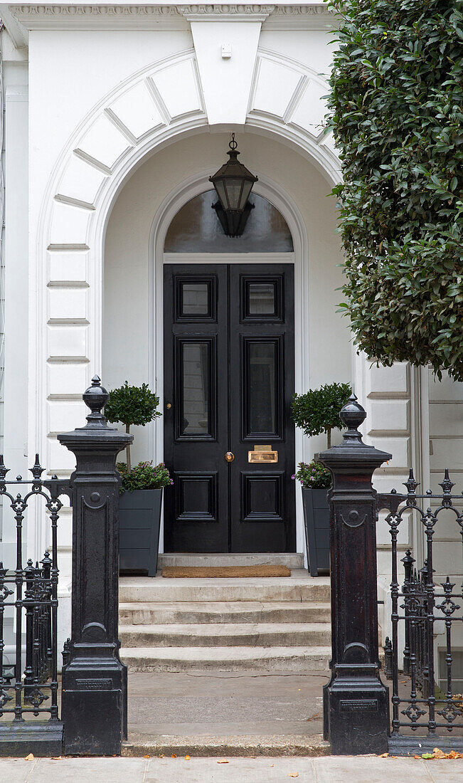 Klassische schwarze Eingangstür und Torpfosten an der Außenseite eines Londoner Stadthauses UK