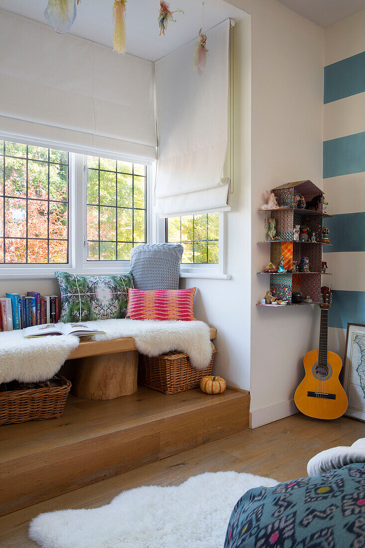 Gitarre und Puppenhaus mit geteilter Fensterbank mit Fellüberwurf in einem Londoner Haus England UK