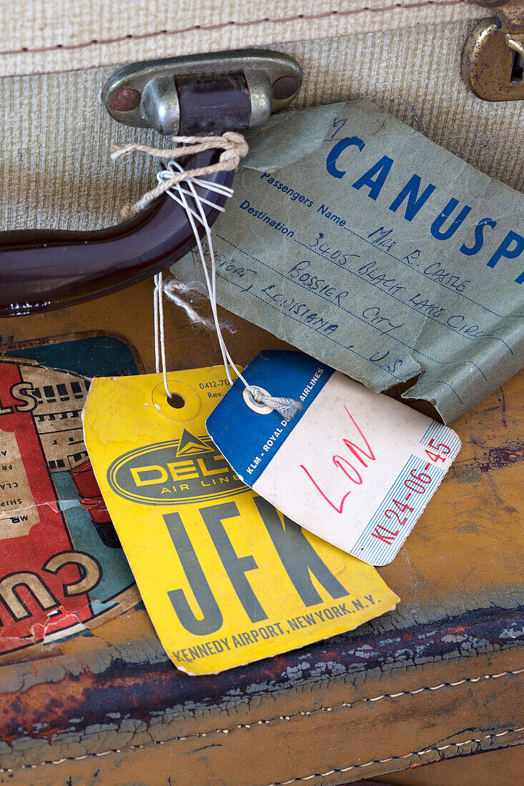 Luggage labels on vintage suitcase in London home England UK