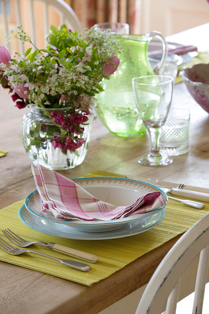 Pink checked napkin and cut flowers at place setting in Grade II listed Georgian country house in Shropshire England UK