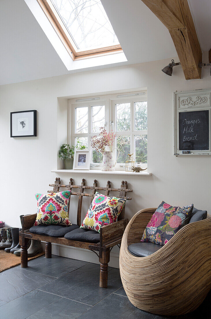 Skylight window over retro style seating in beamed Sussex kitchen England UK