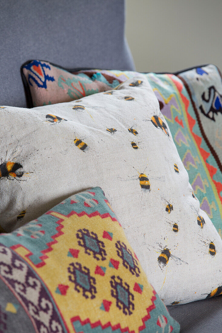 Biene und gemusterte Stoffe bedecken Streukissen in einem Haus in Kelso, Schottland (UK)