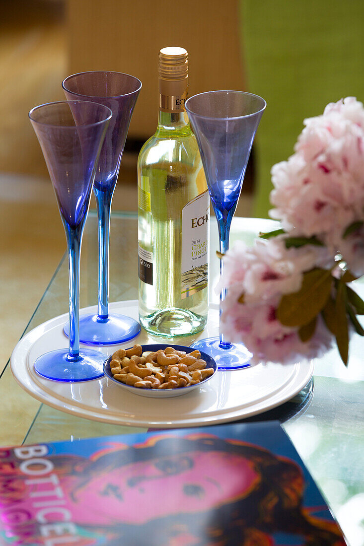 Blue wineglasses and white wine with nuts in London townhouse England UK