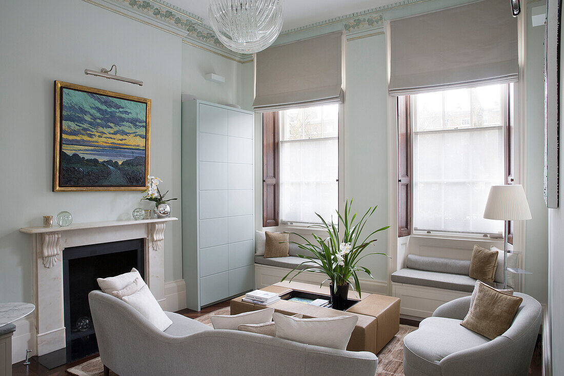 Glas-Pendelleuchte in neutralem Wohnzimmer mit Fensterplätzen in Londoner Stadthaus England UK