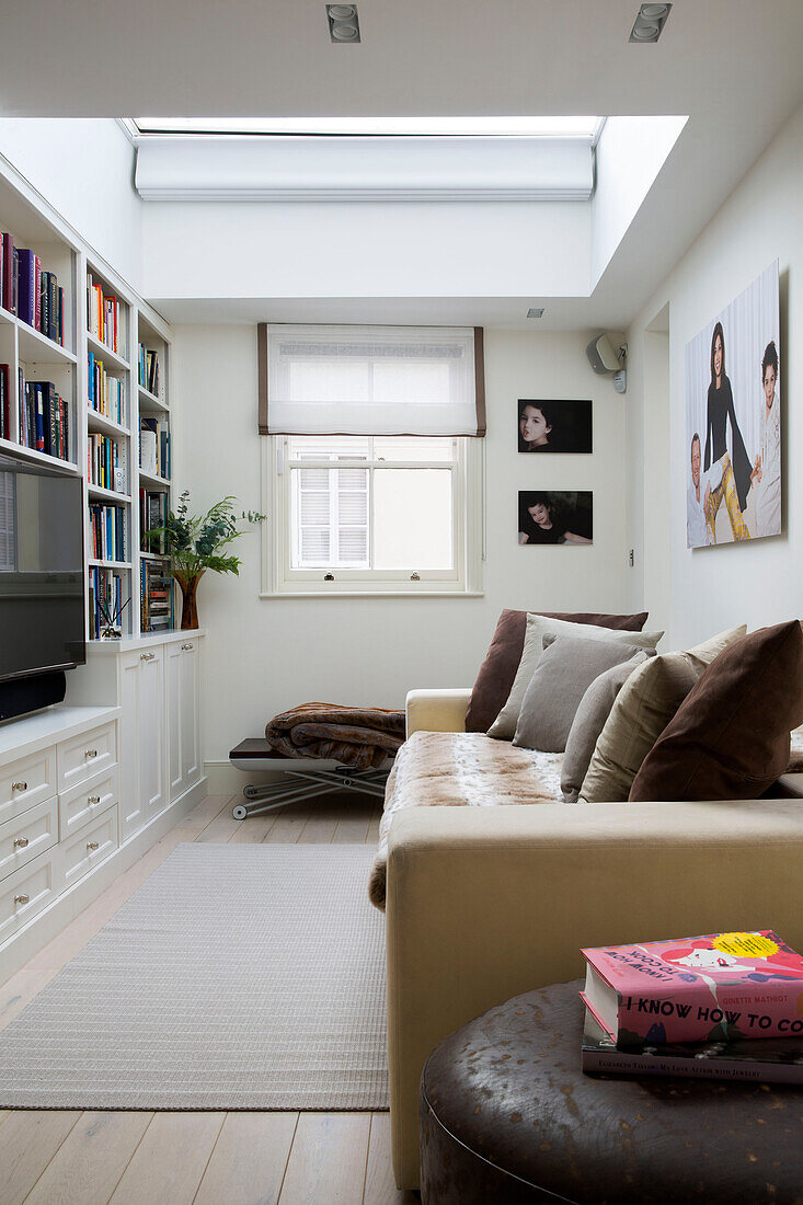Fernseher im Bücherregal mit Sofa in einem Stadthaus in London, England, UK