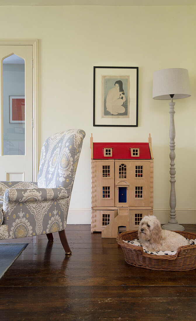 Upcycled armchair with dog in basket dollshouse and standard lamp in Gloucestershire farmhouse England UK