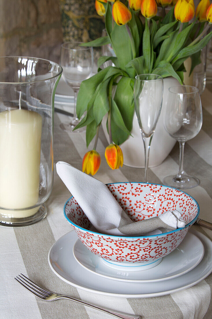 Gedeck mit Kerzen und Tulpen in einem Bauernhaus in Gloucestershire, England, UK