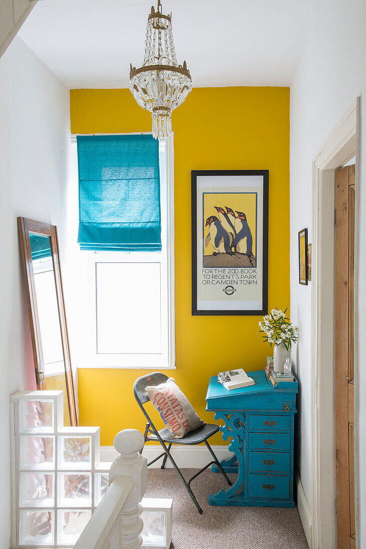 Türkisfarbener Schreibtisch und gelbe Wand am Fenster auf dem Treppenabsatz in einem Haus in Yorkshire England UK