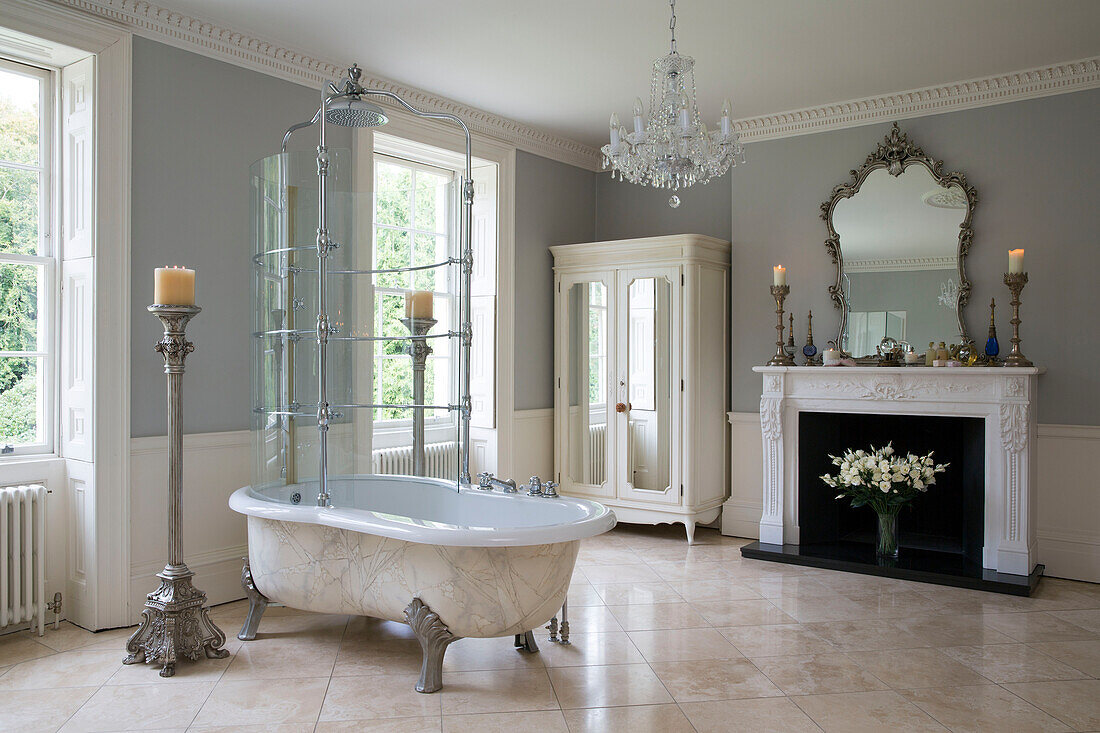 Freistehende Marmorbadewanne mit Duschabtrennung im geräumigen Badezimmer eines Landhauses in Kent, England UK
