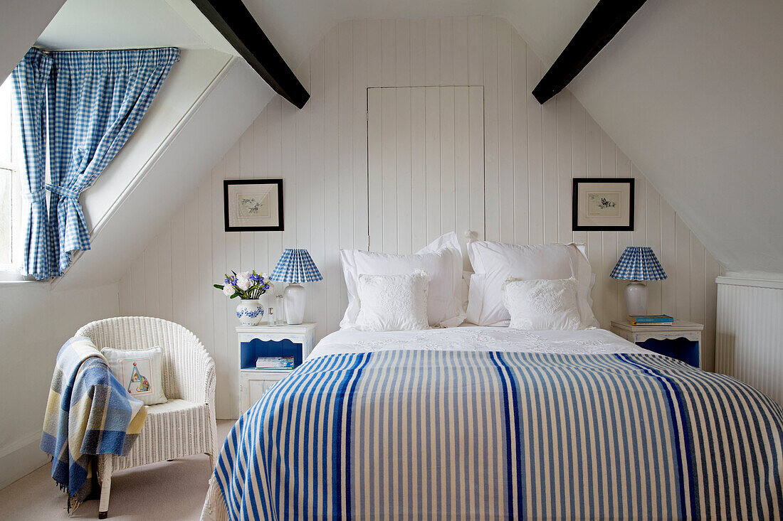 Gestreifte Bettdecke mit koordinierten Gingham-Stoffen im Schlafzimmer im Dachgeschoss eines Bauernhauses in Gloucestershire England UK