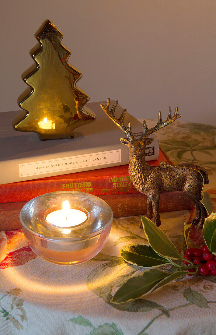 Goldenes Rentier und Weihnachtsbaum mit brennenden Kerzen in einem Bauernhaus in Hampshire England UK