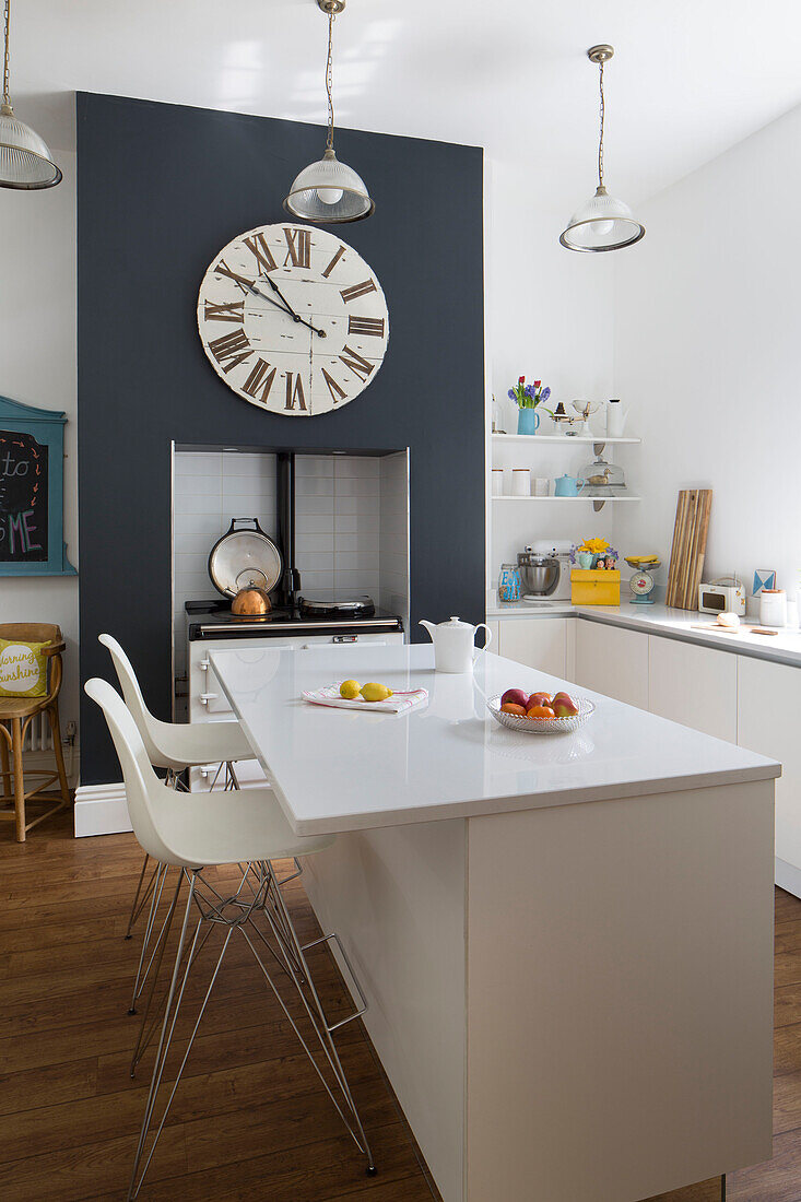 Weiße Barhocker an Kücheninsel mit großer Uhr in Brighouse West Yorkshire UK
