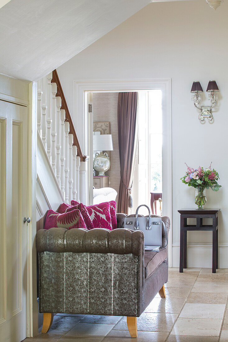 Bag on sofa in hallway of detached Sussex country house UK