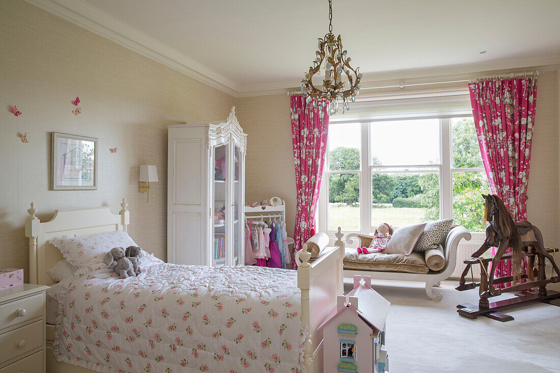 Schaukelpferd und Spielzeug mit Einzelbett im Mädchenzimmer eines freistehenden Landhauses in Sussex UK