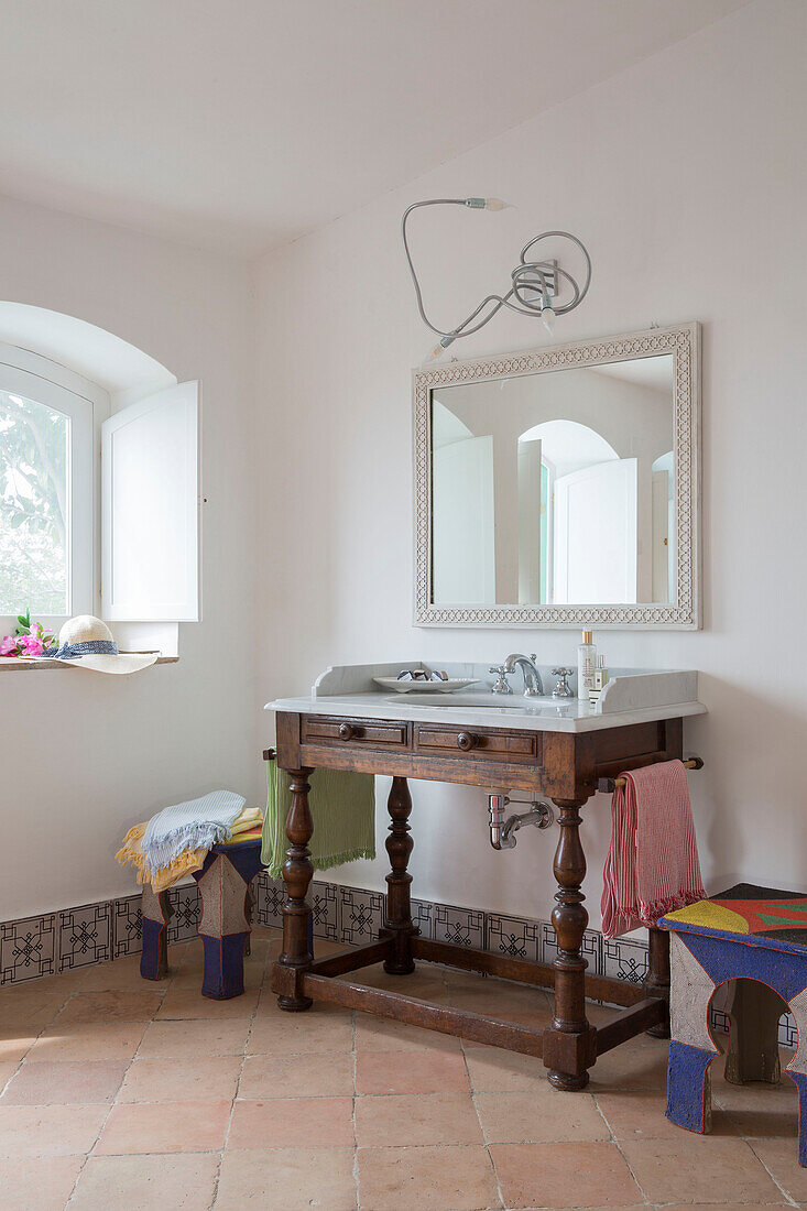 Großer Spiegel über hölzernem Waschtisch am Fenster in italienischer Villa Amalfi Southwest