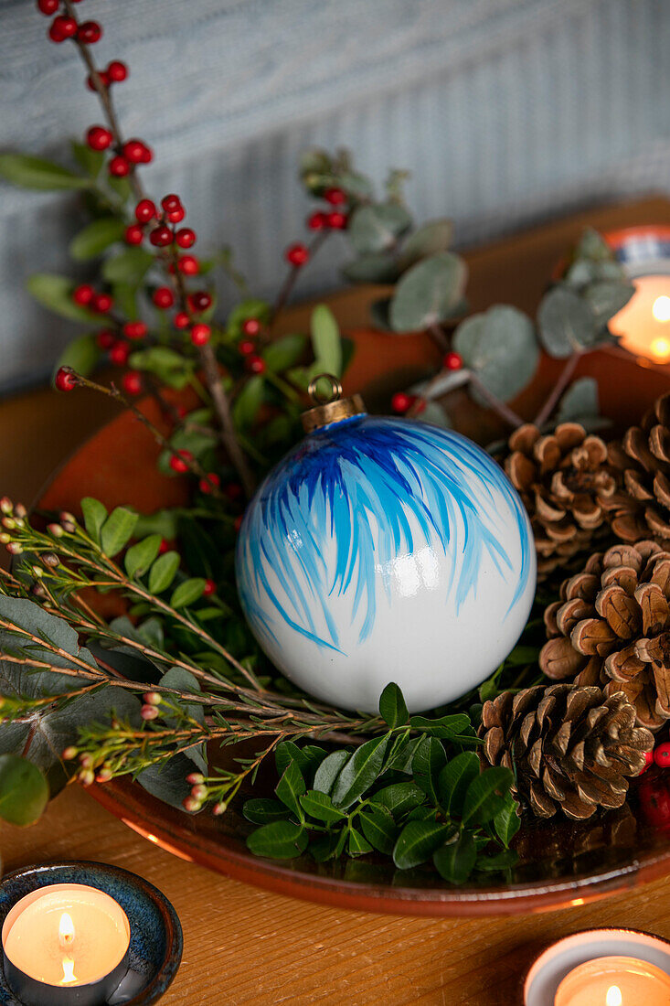 Blue bauble with pinecones and tealights in Berkshire home UK