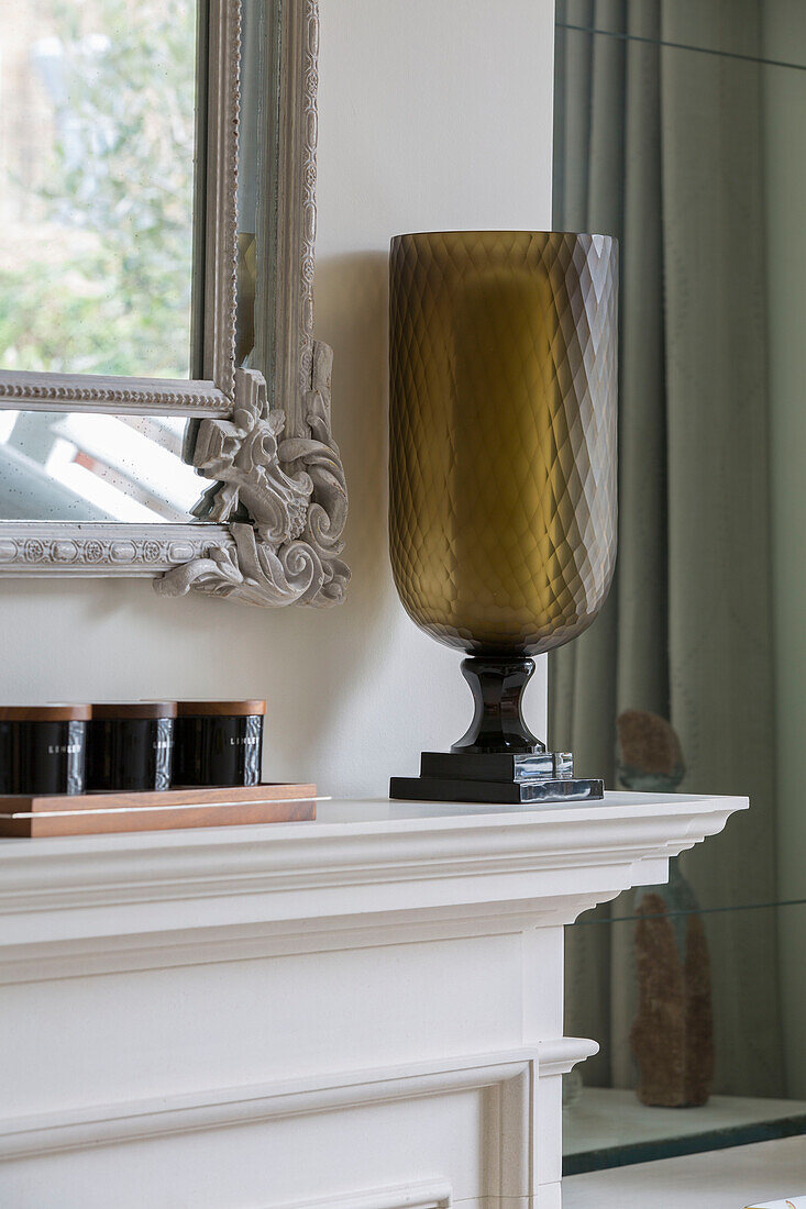 Glass candle holder and storage jars on mantlepiece in London townhouse UK