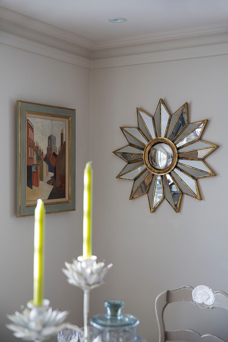 Spiegel mit Sonnenschliff und Kunstwerk mit Kerzen in einem Haus in West Sussex