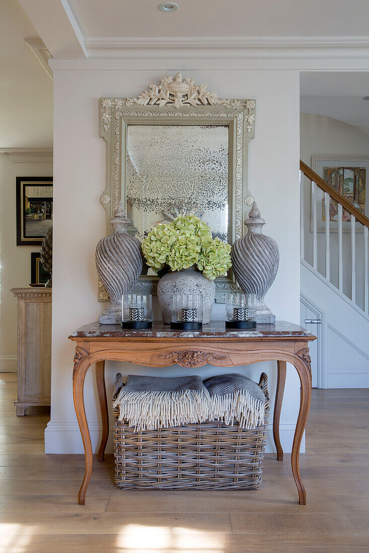 Ornaments and hydrangeas on carved wooden table in West Sussex hallway