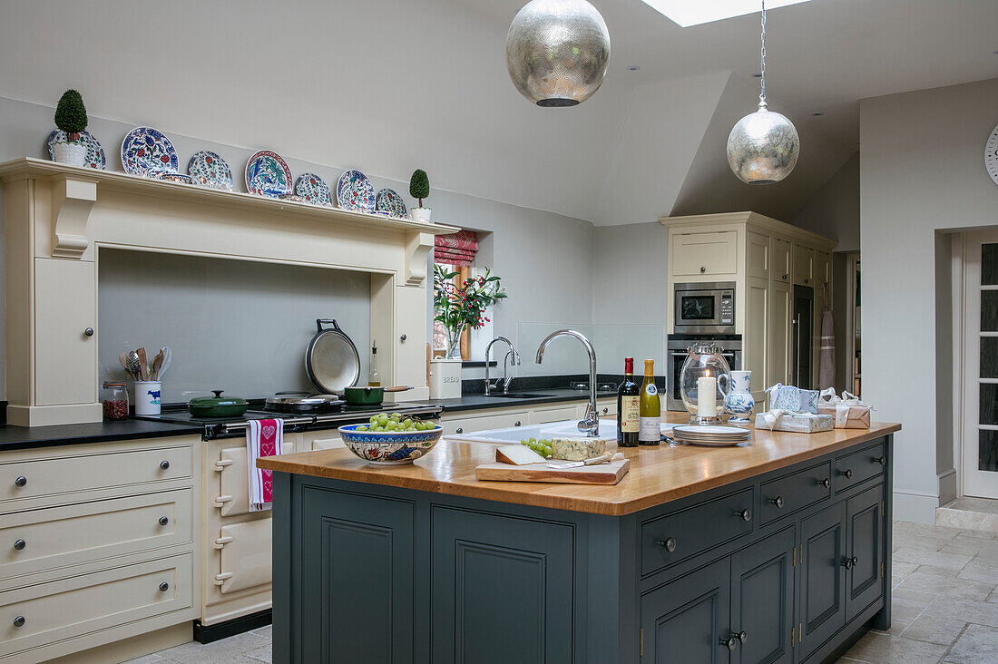 Silberne Pendelleuchte über einer elfenbeinfarbenen Werkbank in einer Bauernhausküche in Dorset UK
