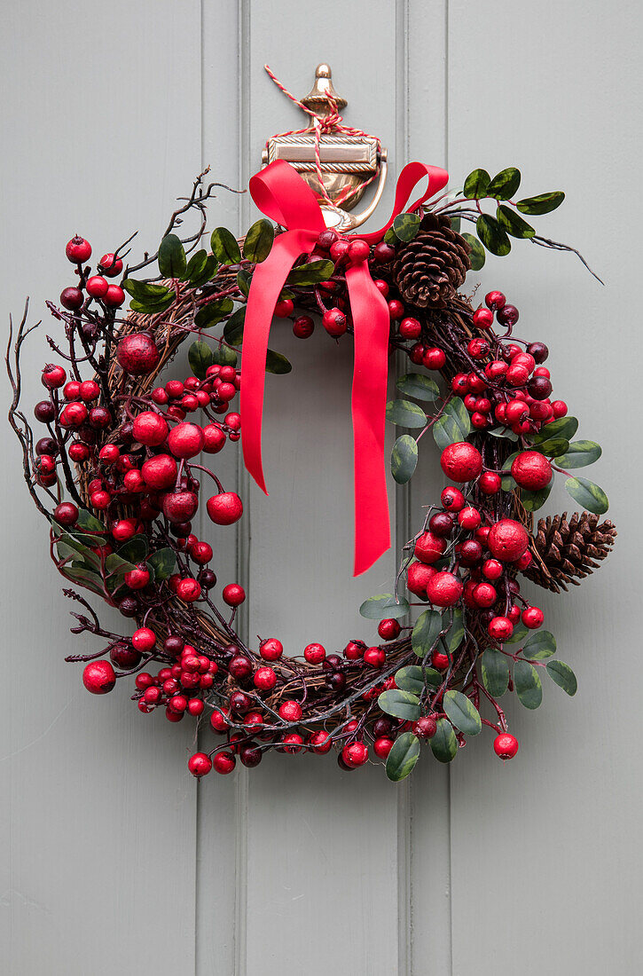 Red ribbon with berries and pinecones on Christmas wreath Liverpool UK
