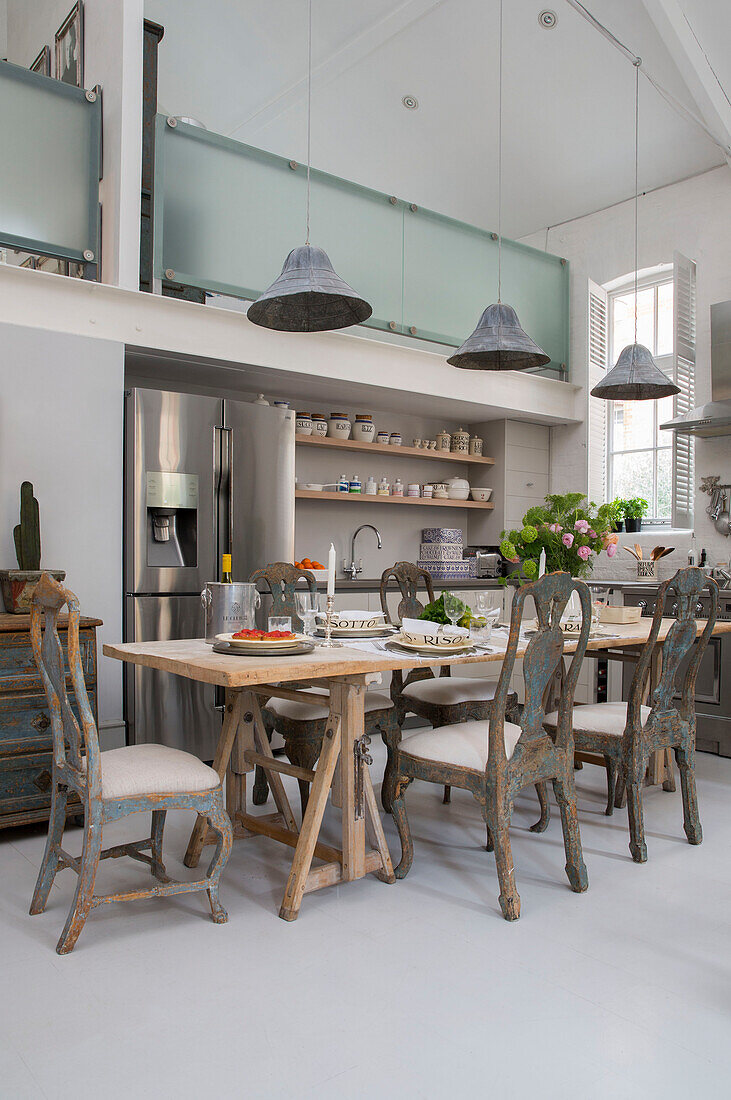pendant lights above dining table in double height South London schoolhouse conversion UK