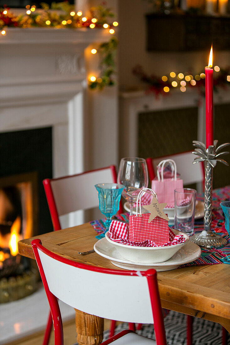 Personalisiertes Gedeck mit angezündeter Kerze auf einem Esstisch zu Weihnachten in einer Wohnung in Hove, East Sussex UK