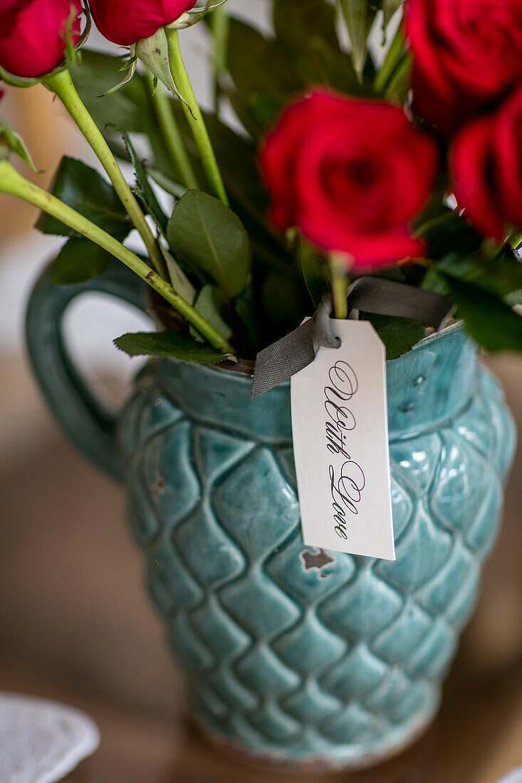 Rote Rosen in einem Keramikkrug 'with love' in einem Londoner Haus UK