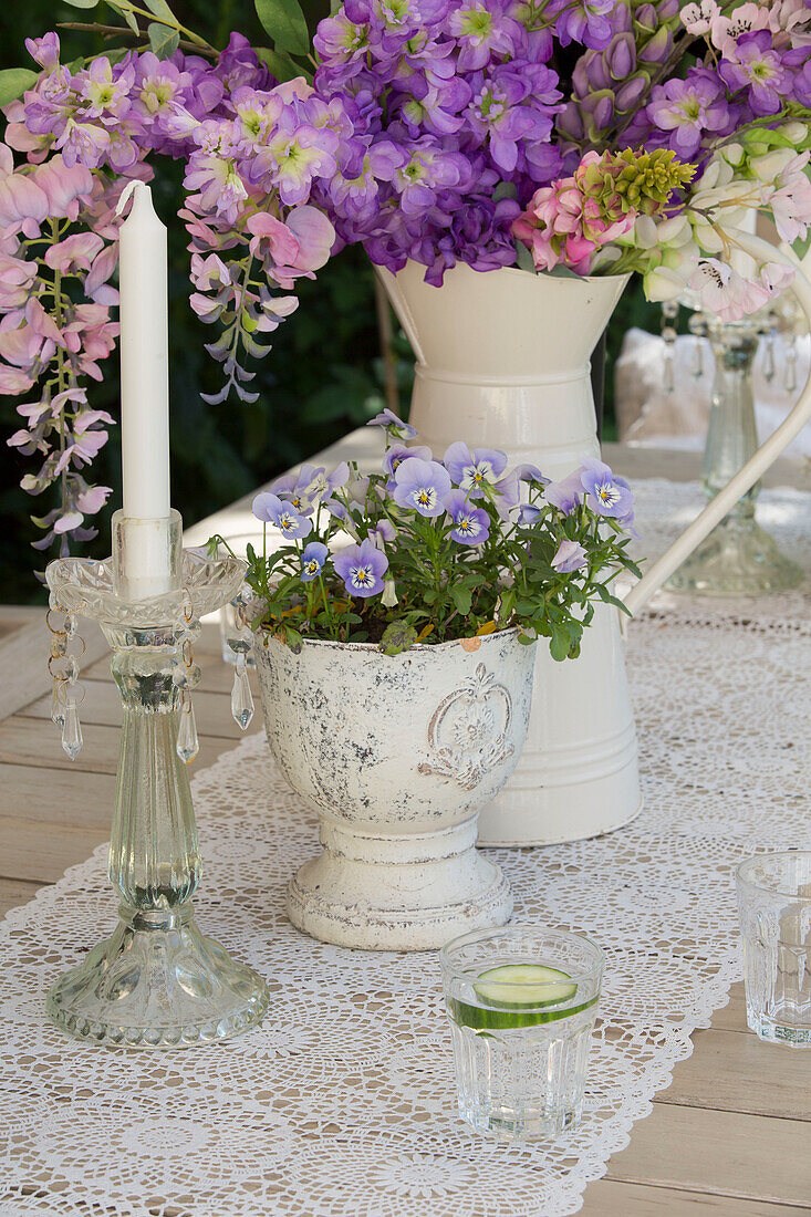 Summer flowers on lace table runner with glass candlestick in Edwardian garden Surrey UK