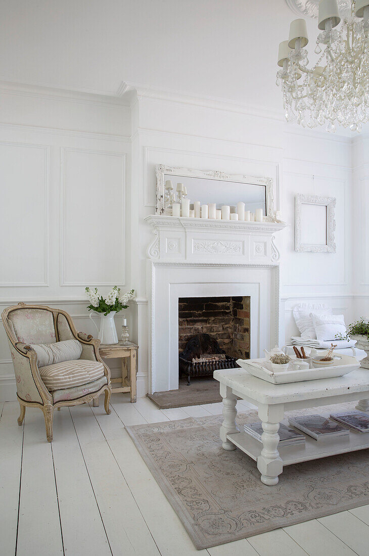 Cream armchair at fireside in white Edwardian living room Surrey UK