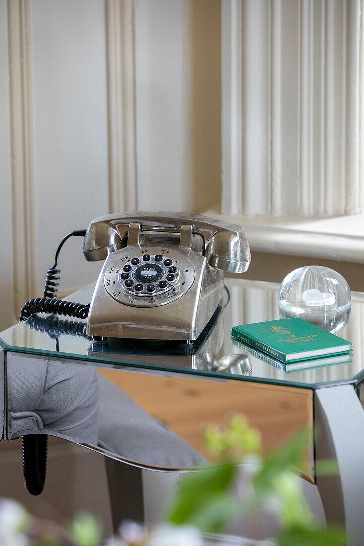 Telefon mit drehbarer Wählscheibe auf einem verspiegelten Beistelltisch in einem Einfamilienhaus in Kent, England