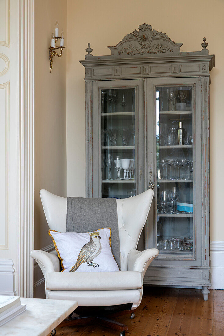 Glasvitrine und weißer Sessel in einem Einfamilienhaus in Kent UK