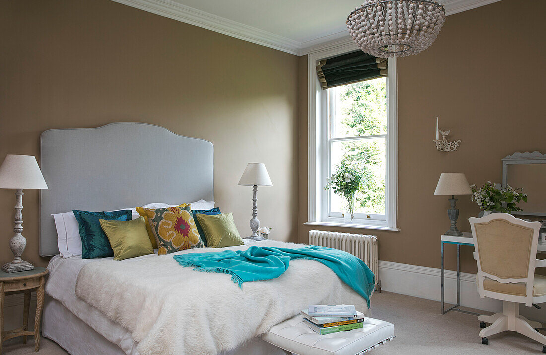 Doppelbett mit großem Kopfteil am Fenster in einem Einfamilienhaus in Kent (UK)