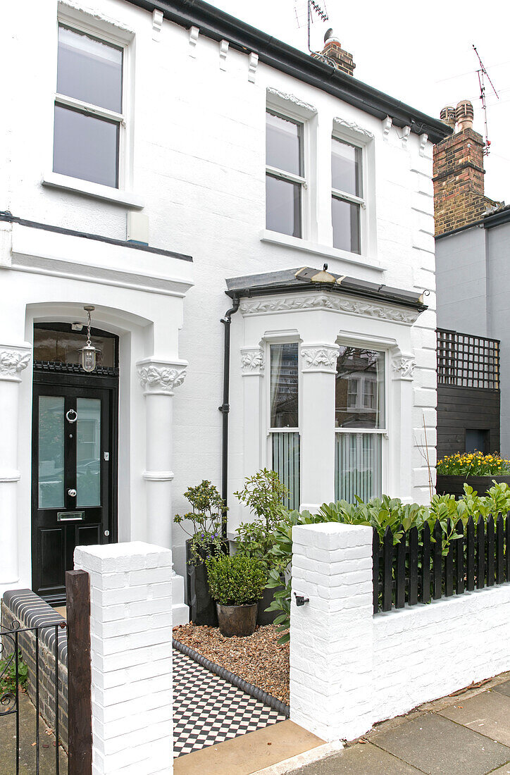 Schwarze Haustür und weißer Anstrich an der Außenseite einer viktorianischen Doppelhaushälfte London UK