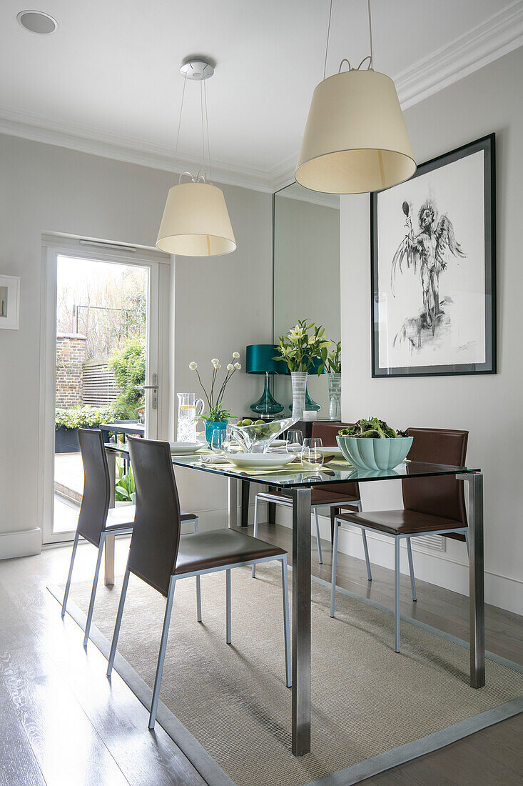 Cremefarbene Pendelleuchten über einem Tisch für vier Personen in einem Haus in London UK