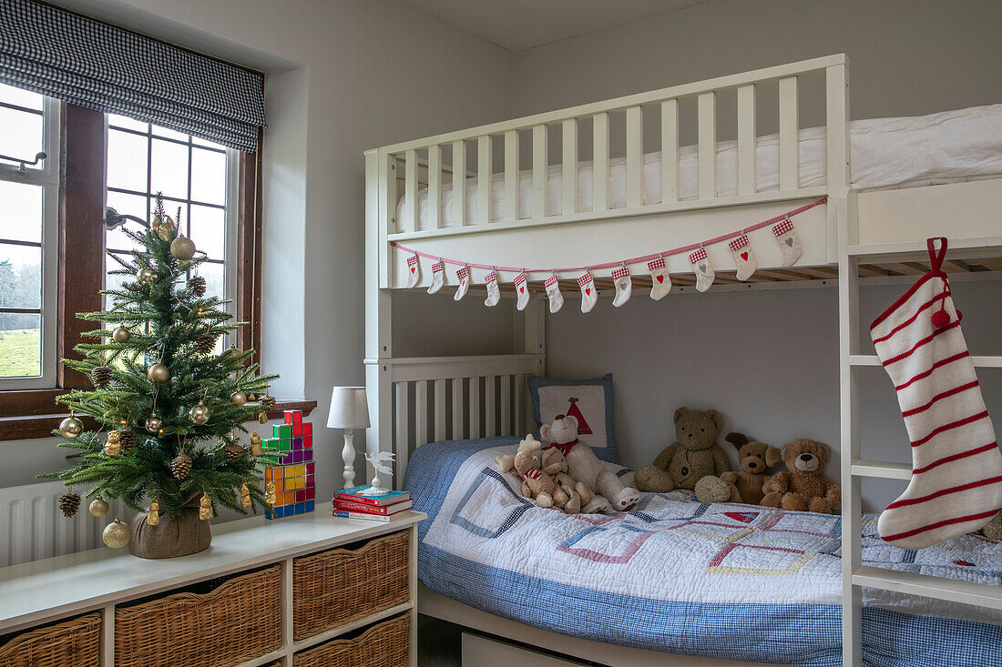 Weihnachtsstrumpf und Weihnachtsbaum mit Teddybären auf dem Etagenbett in einem Haus im Arts-and-Crafts-Stil in West Sussex, Großbritannien