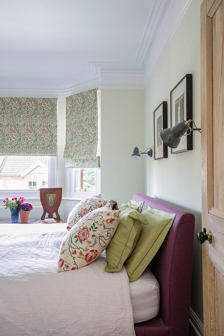 Florale und grüne Kissen mit lila Kopfteil auf dem Bett in einem Reihenhaus in Sevenoaks Kent UK