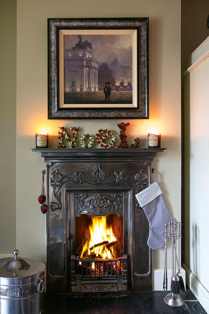 Framed artwork above metallic art deco fireplace in Hampshire home