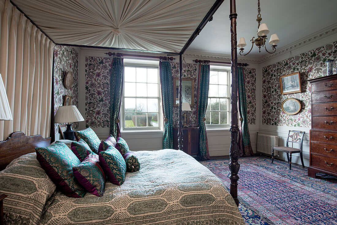 Antikes Himmelbett mit gemischten Seidentextilien und Drucken in einem georgianischen Haus in Hertfordshire England UK