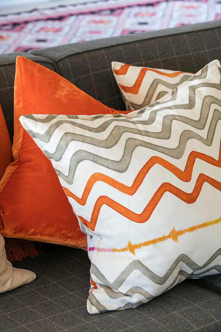 Zigzag patterned and orange cushions on sofa in Hampshire home UK
