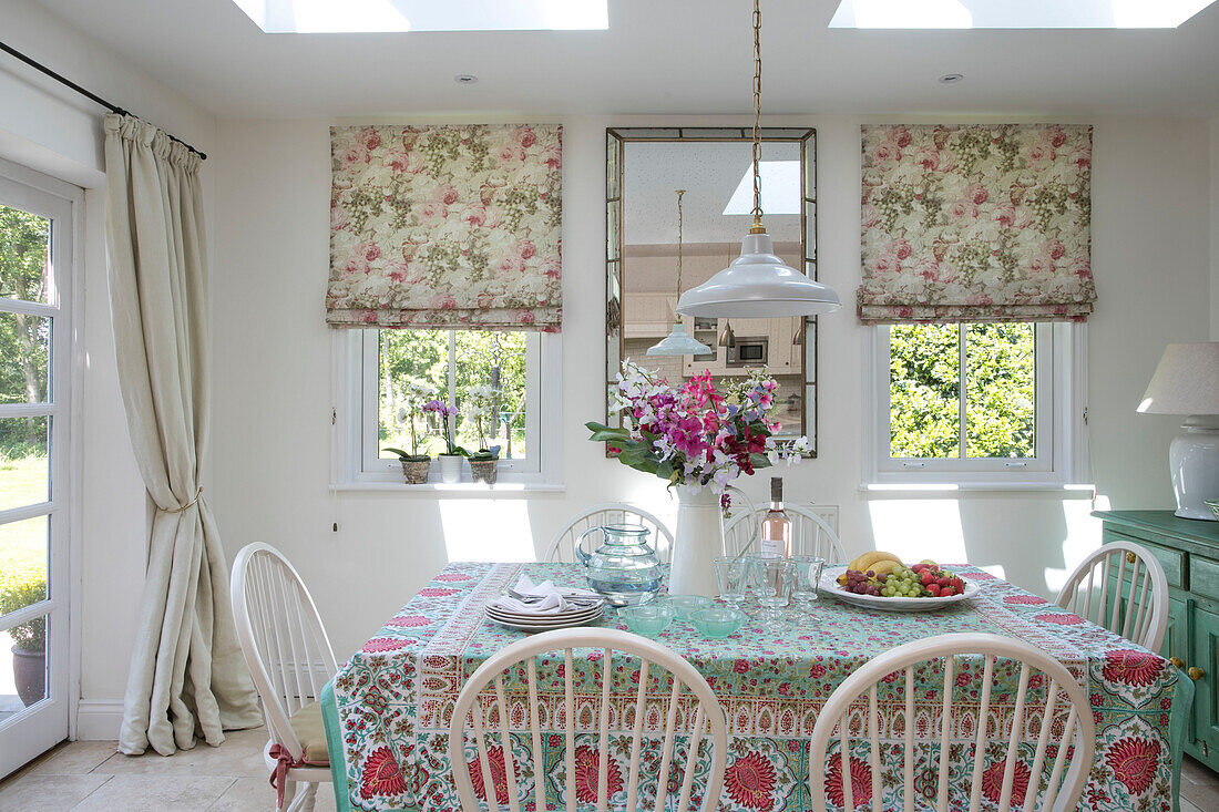 Esstisch und Stühle mit Spiegel unter Dachfenster in Haus in Hampshire UK