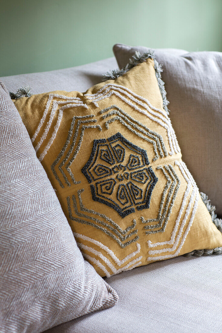 Geometric patterned yellow cushion in 17th century Northamptonshire cottage UK