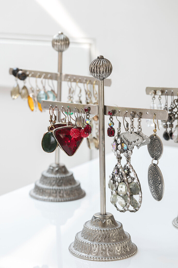 Earrings hang on jewellery stand in North London home UK